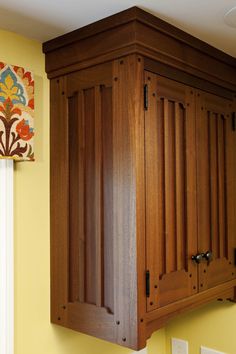 a wooden cabinet mounted to the side of a wall