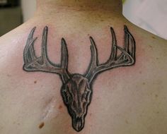 a man with a deer head tattoo on his back