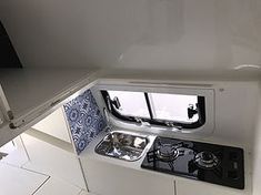 the inside of a small kitchen with an oven and stove top on display in a boat