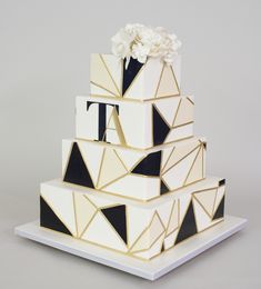 a three tiered cake with black and white geometric designs on it's sides