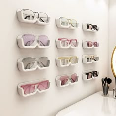 several pairs of sunglasses are hanging on the wall