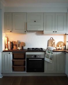 a kitchen with white cabinets and wooden floors