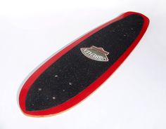 a red and black skateboard sitting on top of a white surface