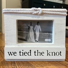 a white wooden frame with the words we tied the knot on it and a photo of a man and woman holding hands