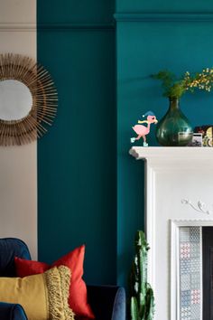 a living room filled with furniture and a fire place in front of a blue wall