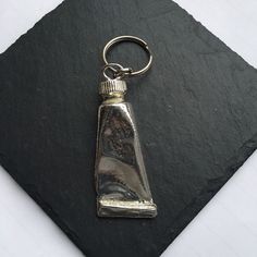 a bottle shaped keychain on top of a slate slab