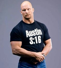 a bald man wearing a black shirt and jeans