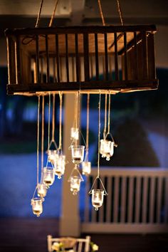 a chandelier made out of mason jars with lights hanging from the top and bottom