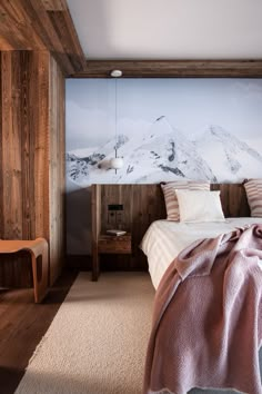 a bedroom with a mountain mural on the wall