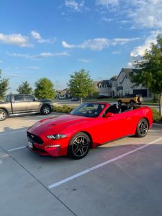 a red convertible car parked in a parking lot