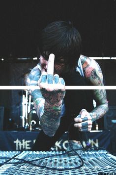 a man with tattoos holding up his hand