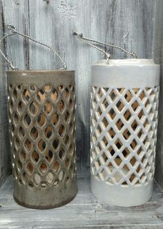 two white vases sitting next to each other on a shelf