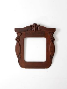 an old wooden frame hanging on the wall with a small hole cut out in it