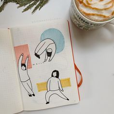 an open notebook with drawings on it next to a cup of coffee and pine branches