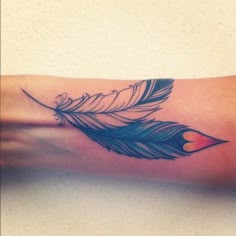 a woman's arm with a feather tattoo on it