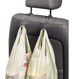 two bags hanging from the back of a car seat