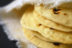 a stack of flat breads sitting on top of a white cloth