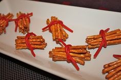 several pieces of pretzels tied with red ribbon on a white plate, ready to be eaten