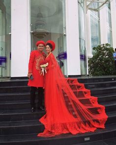 two people dressed in red standing on some steps