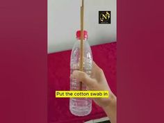 a hand holding a plastic bottle with chopsticks sticking out of it and the caption says put the cotton swab in