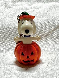 a small figurine sitting on top of a jack - o'- lantern