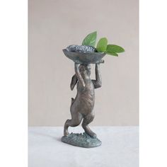 a statue holding a tray with leaves on it