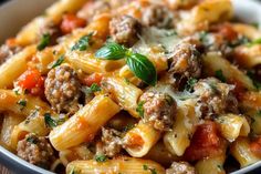 a close up of a bowl of pasta with meat and vegetables