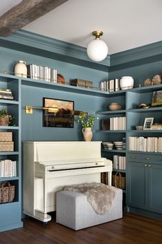 a white piano sitting in front of a bookshelf filled with lots of books