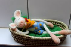 a small stuffed animal laying in a basket