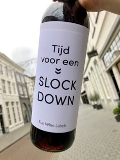 someone holding up a bottle of wine that says tijd voor een stock down