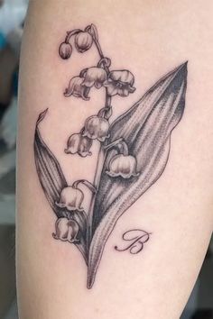 a black and white photo of a lily of the valley tattoo