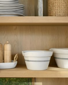 bowls and plates are sitting on the shelves