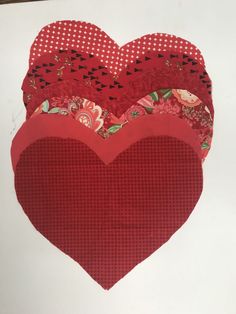 three red heart shaped pieces on top of each other with different patterns and shapes in the middle