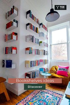 a living room with bookshelves on the wall and a rug in front of it