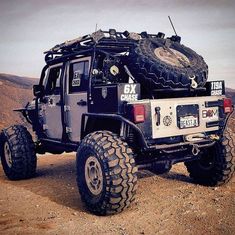 an off - road vehicle is parked in the desert