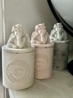 three ceramic animals sitting on top of a table next to each other in front of a mirror