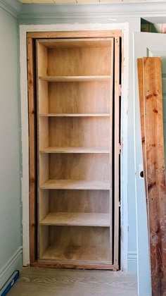 an empty bookcase in the corner of a room that is being built with wood