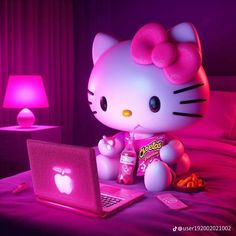 a hello kitty sitting on top of a bed next to a laptop computer and pink light