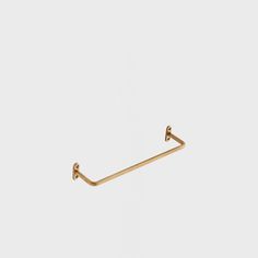 a gold - plated metal hook on a white background