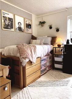 a bedroom with a bed, dresser and pictures on the wall