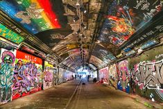 the inside of a subway station with graffiti all over it's walls and ceiling