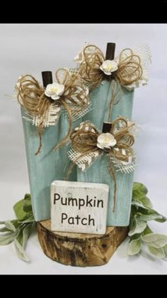 two vases made out of wood with burlocks and flowers on them, each holding a sign that says pumpkin patch