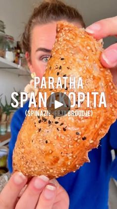 a woman holding up a sandwich in front of her face with the words sparata spanopita on it