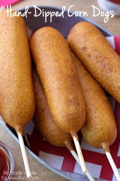 four fried corn dogs in a pan with toothpicks