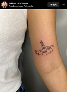 a woman's arm with a tattoo on it that has a boat in the water