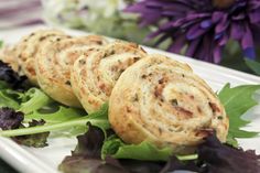 some food is laying out on a plate with lettuce and purple flowers in the background