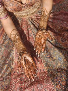 a woman's hands decorated with hennap