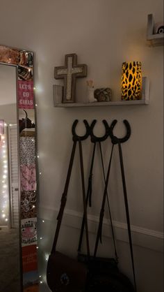 there is a cross on the wall next to a mirror and coat rack in this room