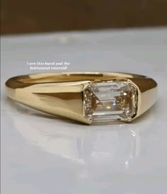 a gold ring with an emerald cut diamond