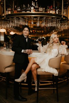 a man and woman sitting at a bar